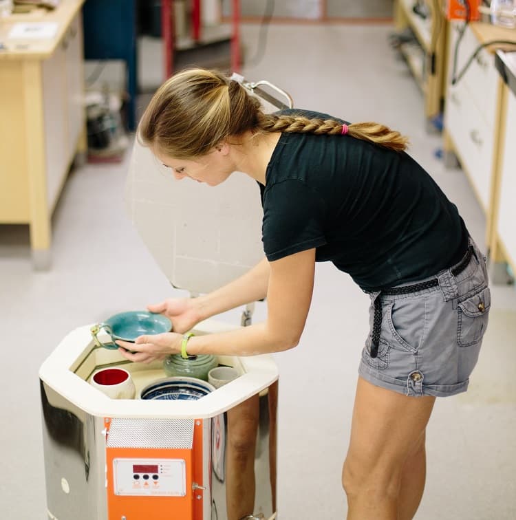 Woman unloading ceramics from a Jen-Ken Kilns 1513 "The Emerge" kiln 